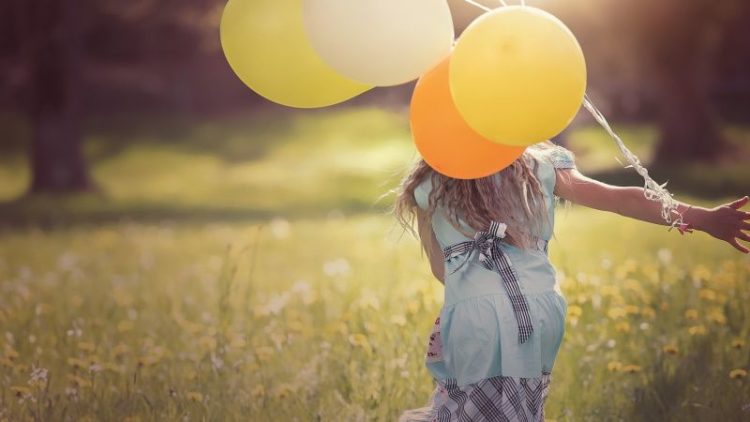 maedchen mit luftballons auf wiese