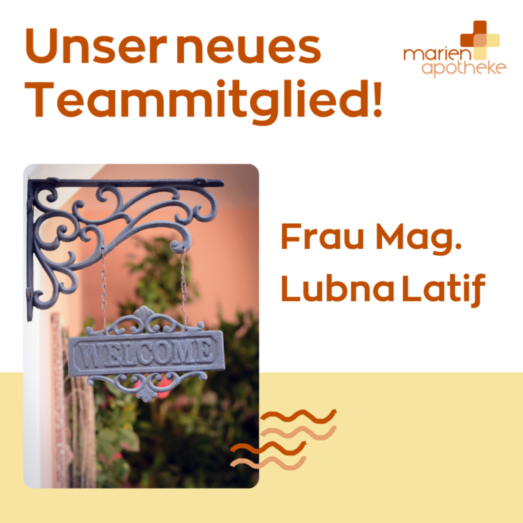 Ein Willkommensschild mit geschwungenem Halter, im Hintergrund eine grüne Pflanze und eine rosa Wand.