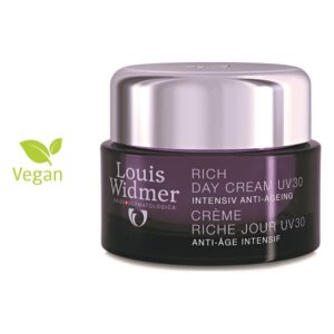 Eine violette Tagescreme mit UV-Schutz und Anti-Aging-Eigenschaften im glänzenden Tiegel, vegan gekennzeichnet.