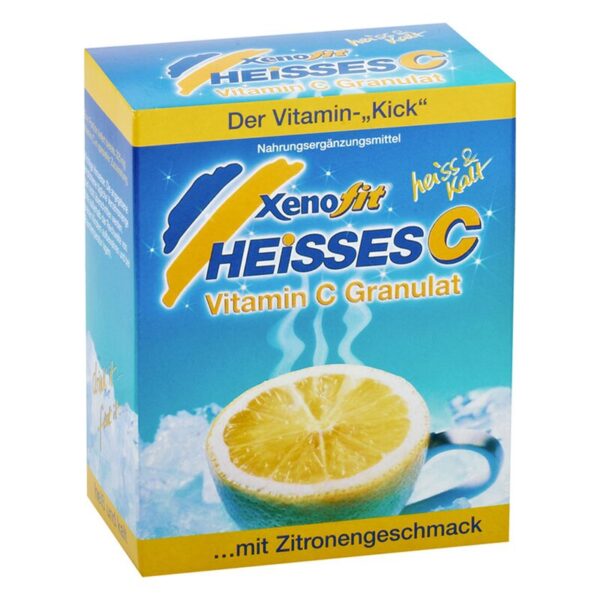 Verpackung von Xeno fit Heißes C Vitamin C Granulat mit Zitrone, grüne Tasse, dampfender Inhalt, hellblauer Hintergrund.