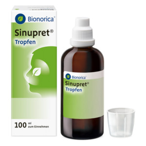 Bionorica Sinupret Tropfen in brauner Flasche mit weißem Tropfverschluss und Messbecher, Umkarton im Hintergrund.