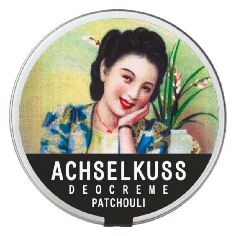 Runde Dose mit Deocreme, dekoriert mit einer lächelnden Frau im Retro-Stil und dem Schriftzug "ACHSSELKUSS DEOCREME PATCHOULI".
