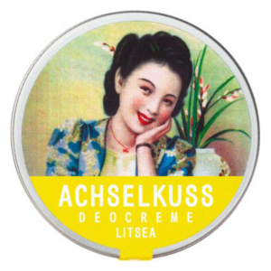 Runde Dose mit Deocreme, verziert mit einem nostalgischen Frauenporträt und grünen Pflanzen im Hintergrund.