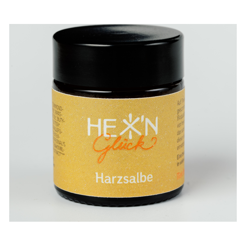Schwarzes Tiegelchen mit gelbem Etikett für Harzsalbe, beschriftet mit "HEX' N Glück".