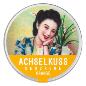 Runde Dose mit Deocreme in leuchtendem Orange, verziert mit einer lächelnden Frau und floralem Hintergrund.