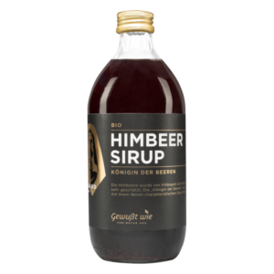 Flasche mit Bio-Himbeersirup, dunkelrote Flüssigkeit, schwarzes Etikett mit goldener Schrift.